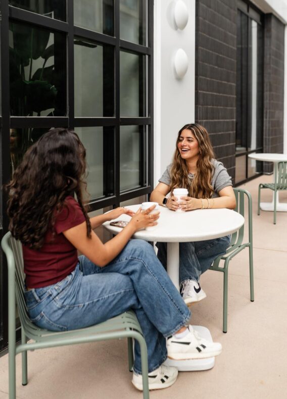 two girls talking over a coffee daydreamer coffee outside