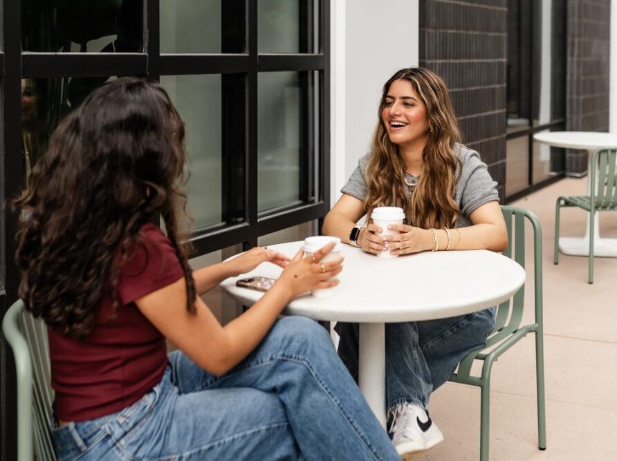 two girls talking over a coffee daydreamer coffee outside