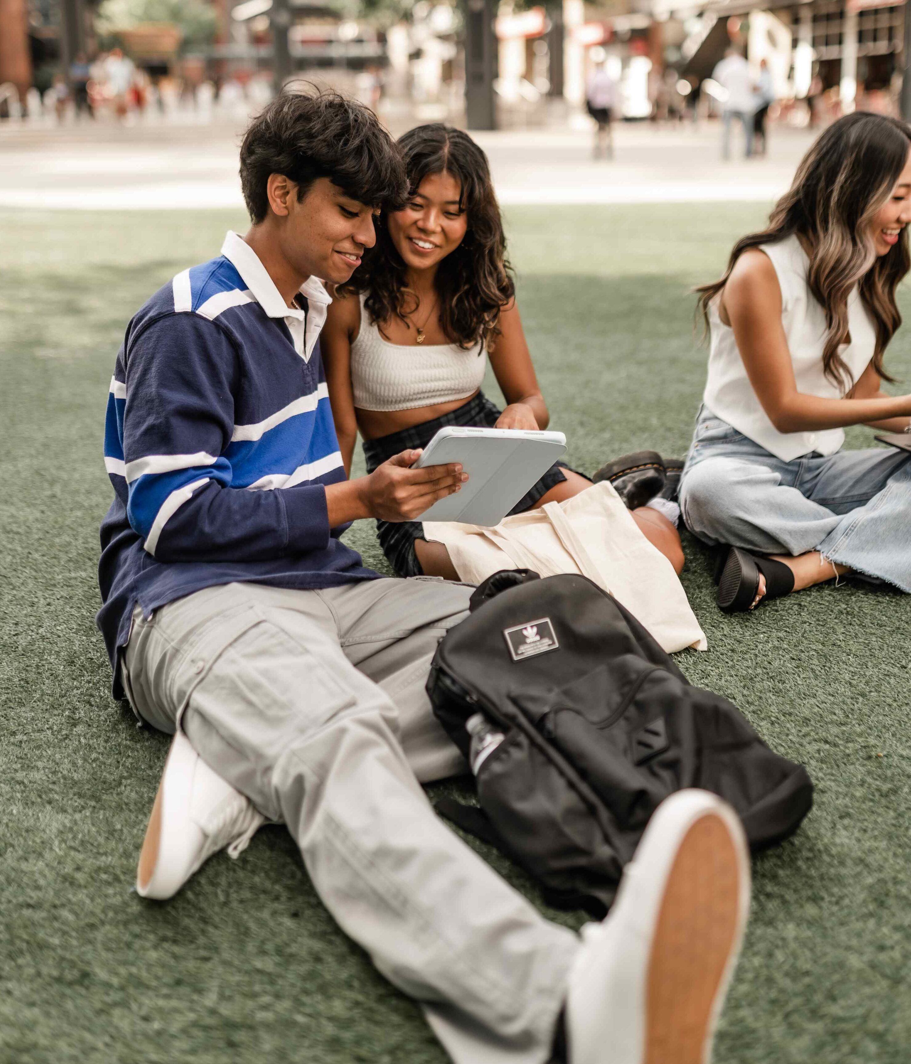 Boy and girl sitting on the grass looking at a notebook in Atlanta